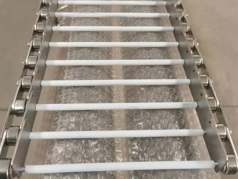 如何根据实际情况调整链板输送带的输送速度？